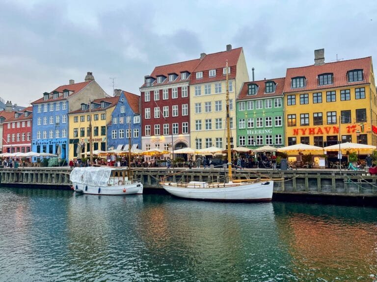 Canal historique de Nyhavn à Copenhague en hiver, avec bateaux au premier plan et maisons colorées typiques en arrière-plan
