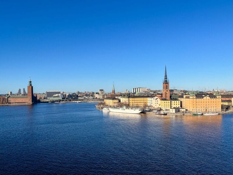 Vue ensoleillée sur Riddarfjärden à Stockholm avec au second plan l’église Riddarholmskyrkan et l’hôtel de ville Stockholms stadshus, lors d’une visite hivernale