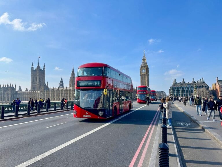 Pont menant à Big Ben avec bus impériaux rouges et Westminster en arrière-plan, lors d’une visite de Londres